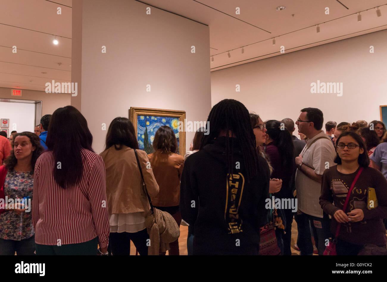 Persone affollarsi intorno a guardare Vincent Van Gogh notte stellata attualmente sul display di MoMA galleria di arte moderna. Foto Stock
