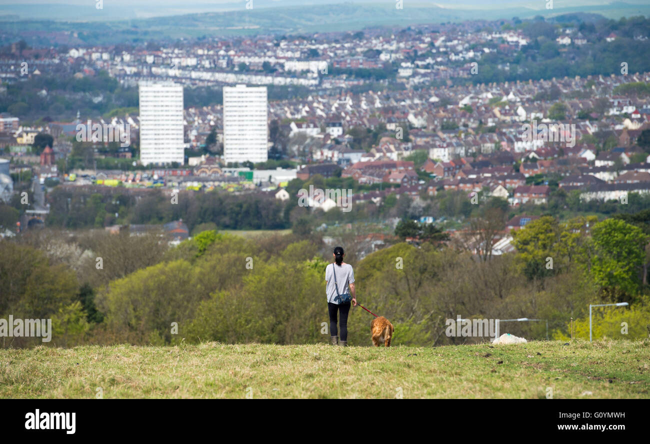 Brighton Regno Unito 6 Maggio 2016 - Una giovane donna prende il suo cane per una passeggiata mattutina attraverso dell'inquilino giù in Brighton godendo della calda primavera meteo e alcuni dei migliori panorami della città Credito: Simon Dack/Alamy Live News Foto Stock