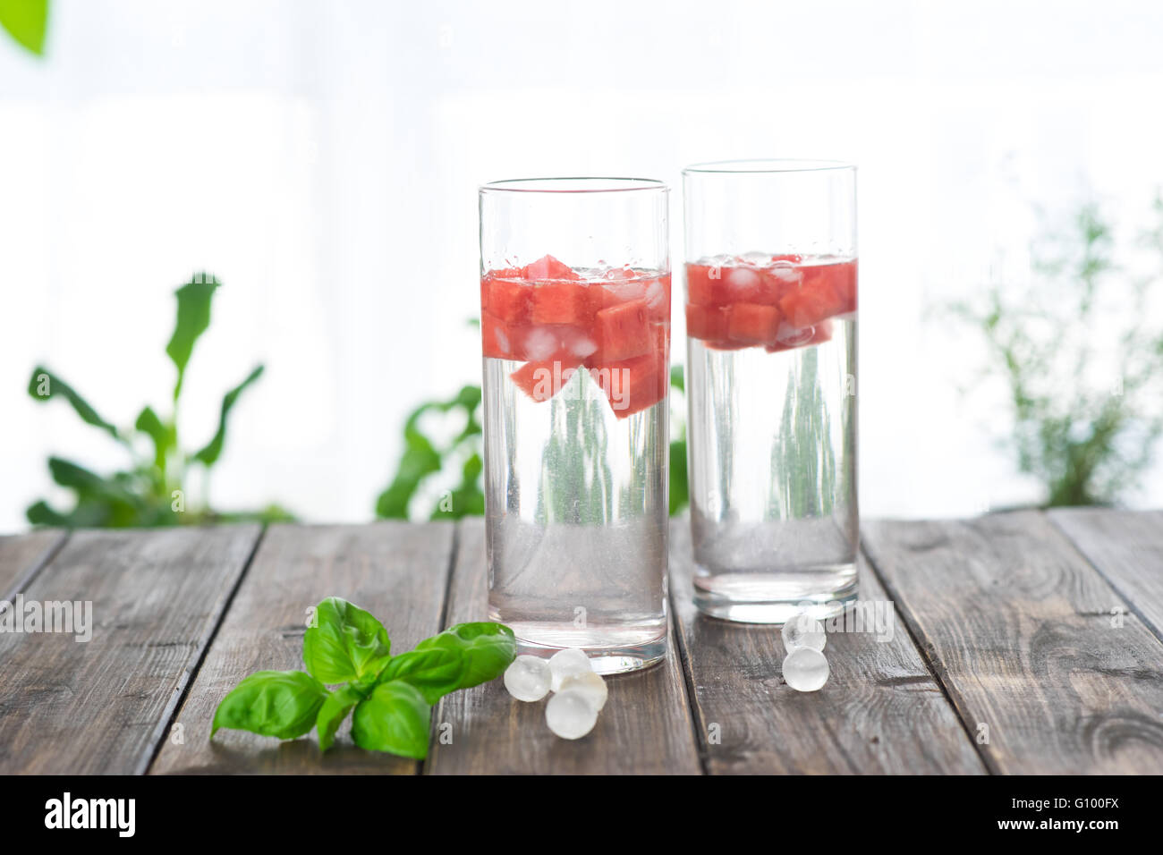 Detox acqua con anguria in due bicchieri sul tavolo di legno posto accanto alla finestra Foto Stock