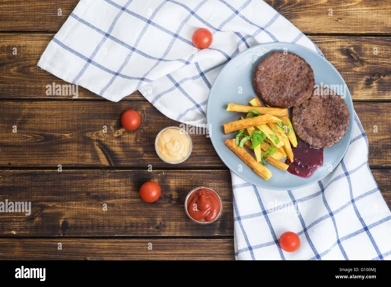 Due hamburger di manzo con patate fritte sul tavolo di legno con vista superiore Foto Stock