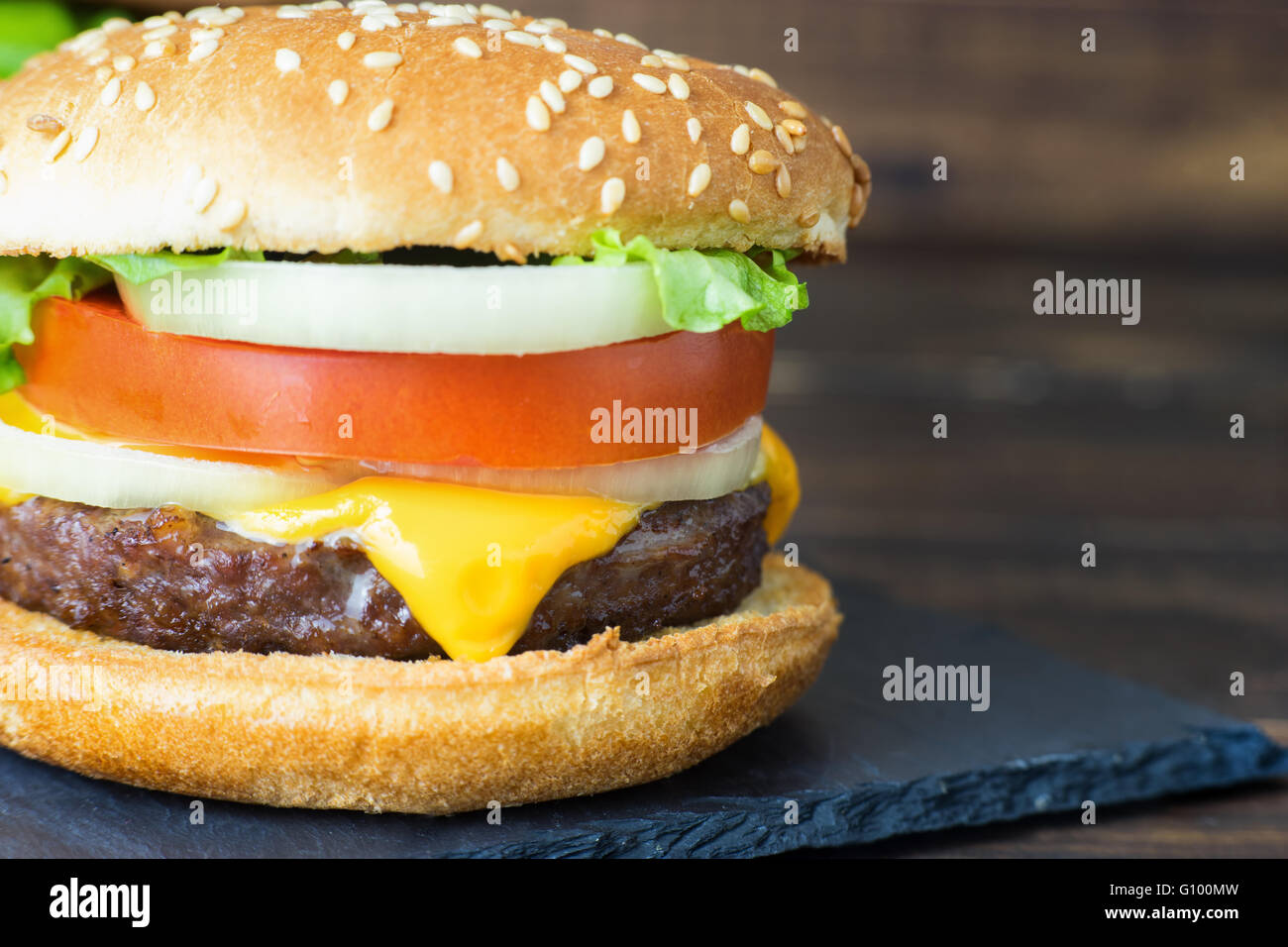 Close up deliziosa casa cheeseburger su una piastra di ardesia in stile rustico Foto Stock