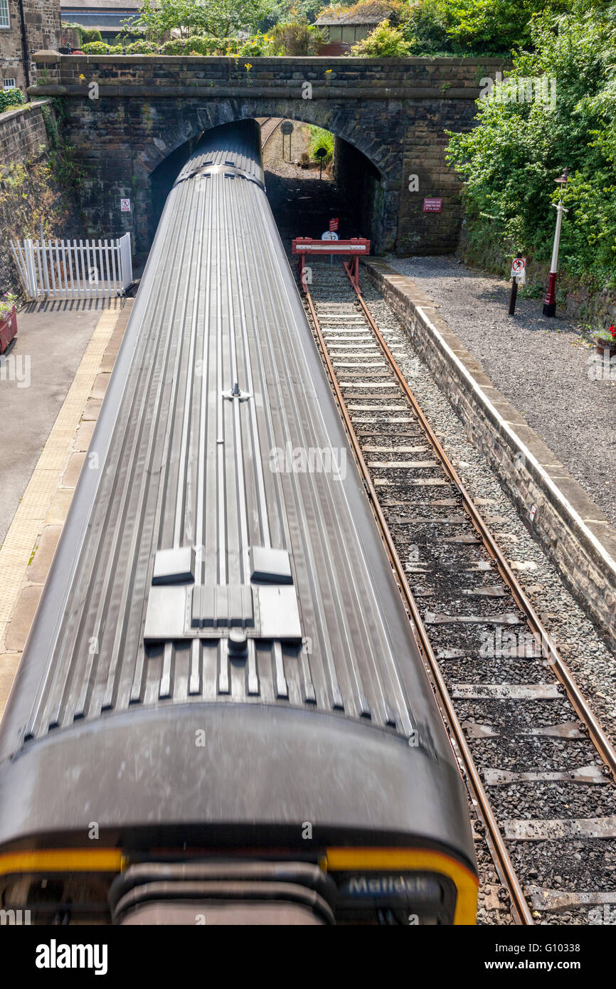 Treno DMU, visto da sopra, viaggiando sotto un ponte ferroviario a Matlock, Derbyshire, England, Regno Unito Foto Stock