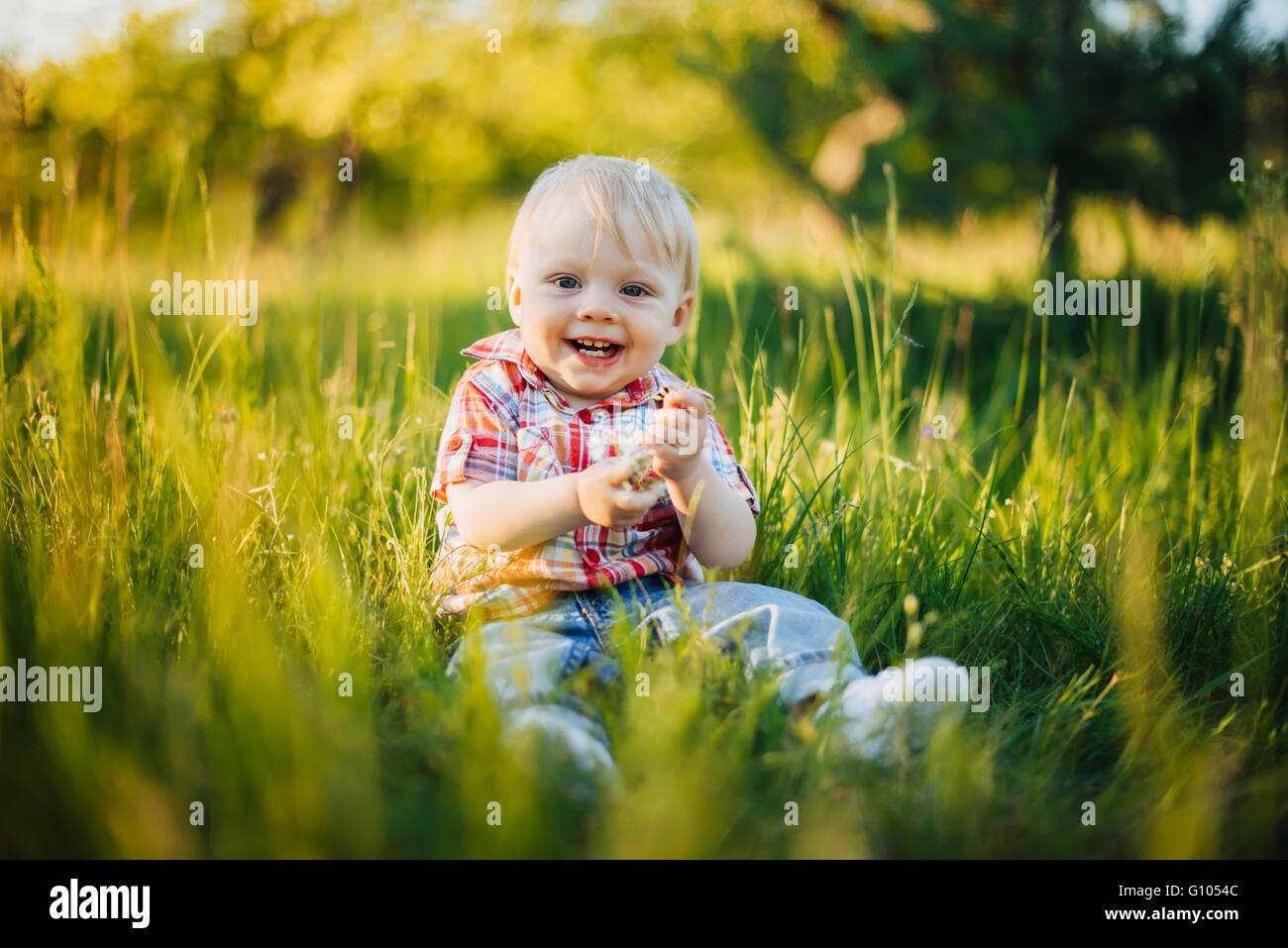 Bambino seduto sull'erba Foto Stock