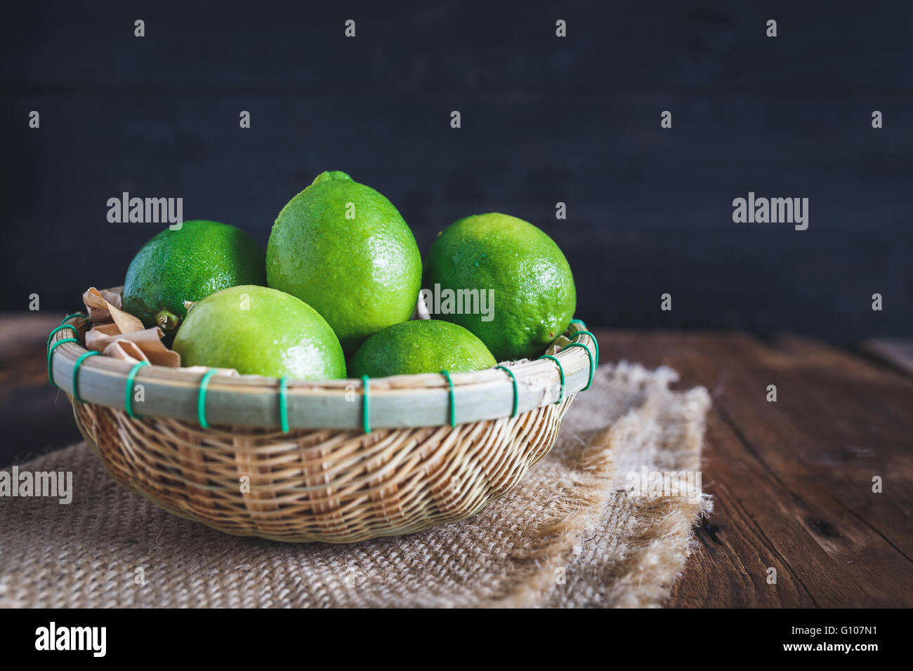 Limoni verde sul legno vecchio Foto Stock