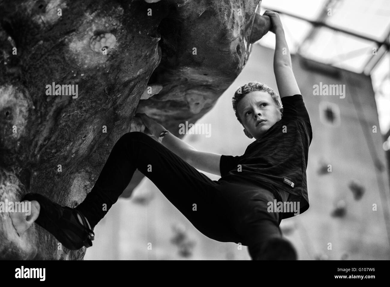 Un giovane ragazzo la scalata al National Indoor centro di arrampicata in Ratho, Edimburgo Foto Stock