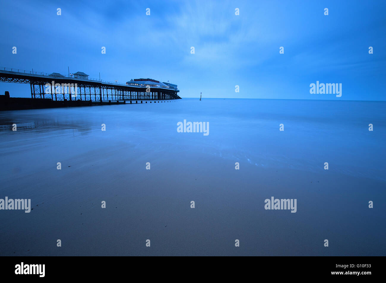 Lunga esposizione della spiaggia a Cromer Pier appena prima del tramonto Foto Stock