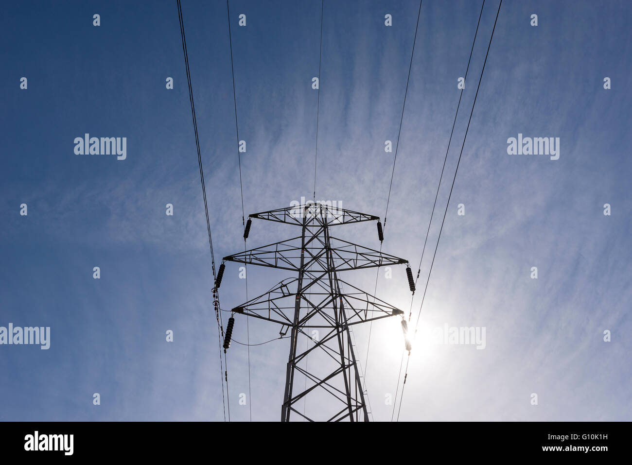 Guardando in alto nel frame di un traliccio di elettricità con cielo blu chiaro overhead. Foto Stock