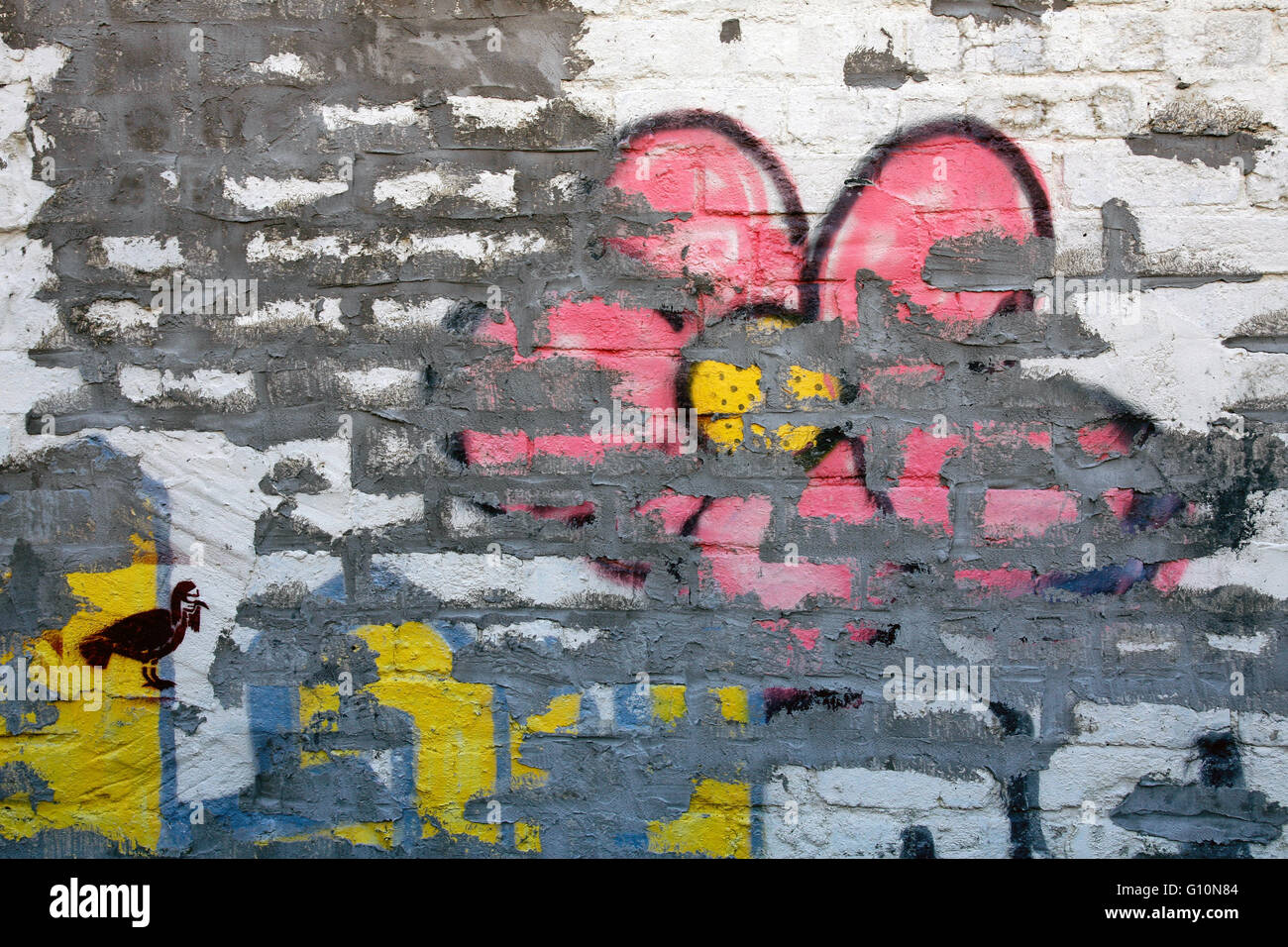 Rosa e giallo fiore graffiti su un bianco muro di mattoni Foto Stock