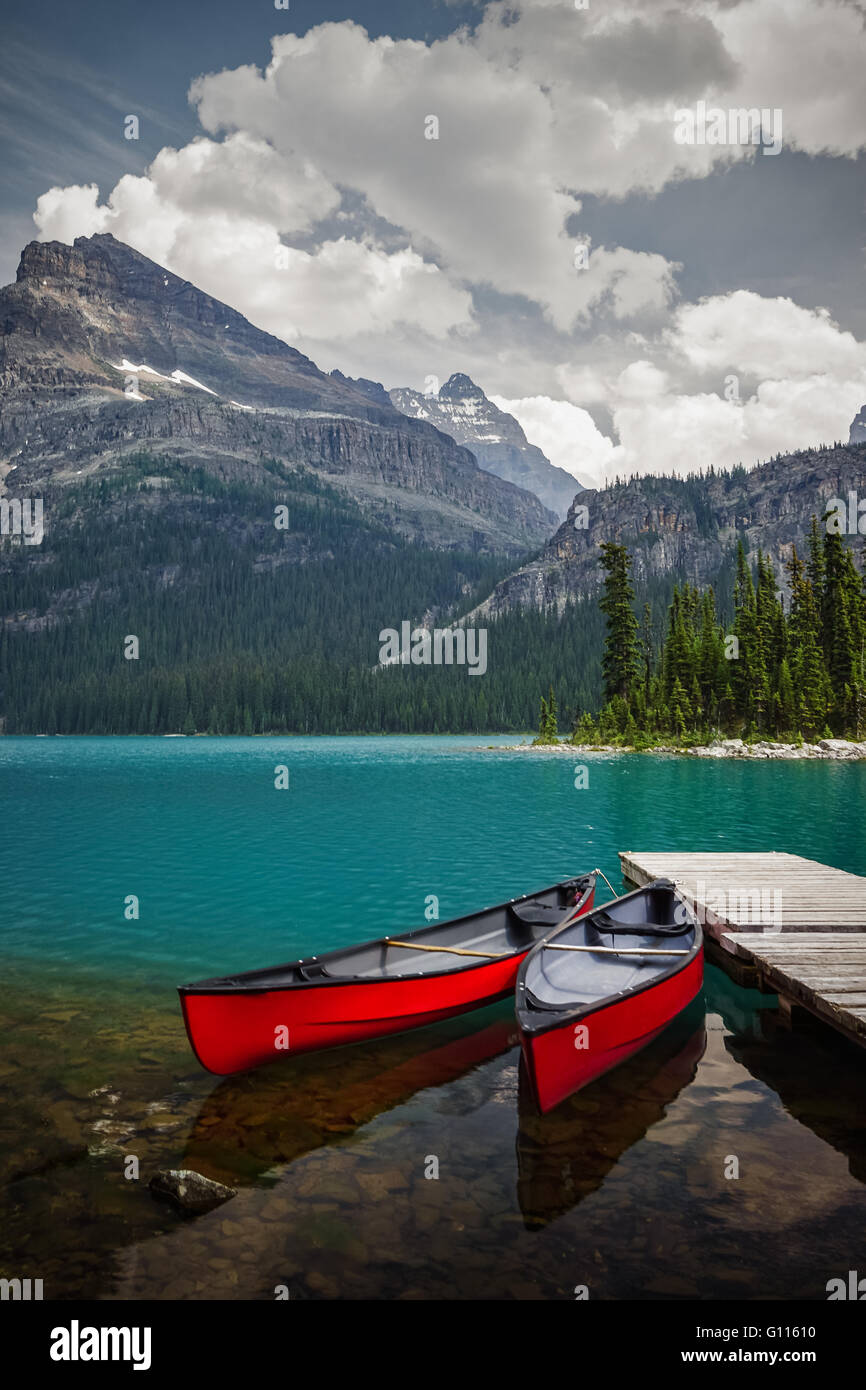 Red canoe sembrano perfettamente collocato e in attesa presso il lago O'Hara nel Parco Nazionale di Yoho, Canadian Rockies, British Columbia Foto Stock