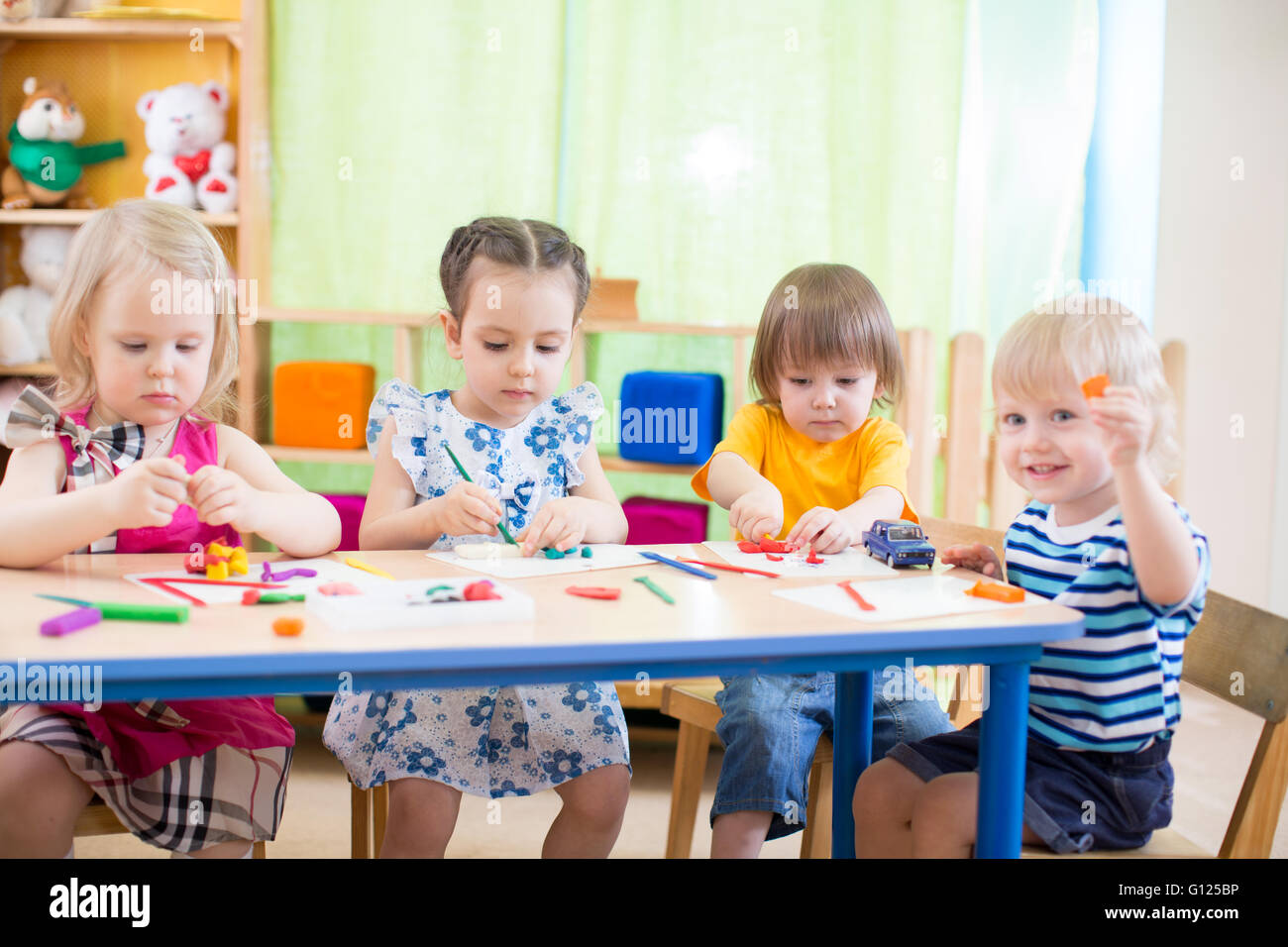 I ragazzi di apprendimento di gruppo con interesse arti e mestieri in centro diurno sala giochi Foto Stock