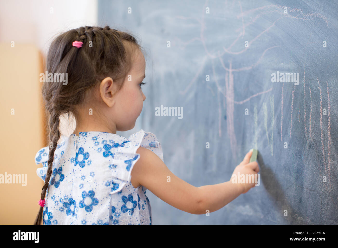 Bambina vista laterale nei pressi di Blackboard Foto Stock