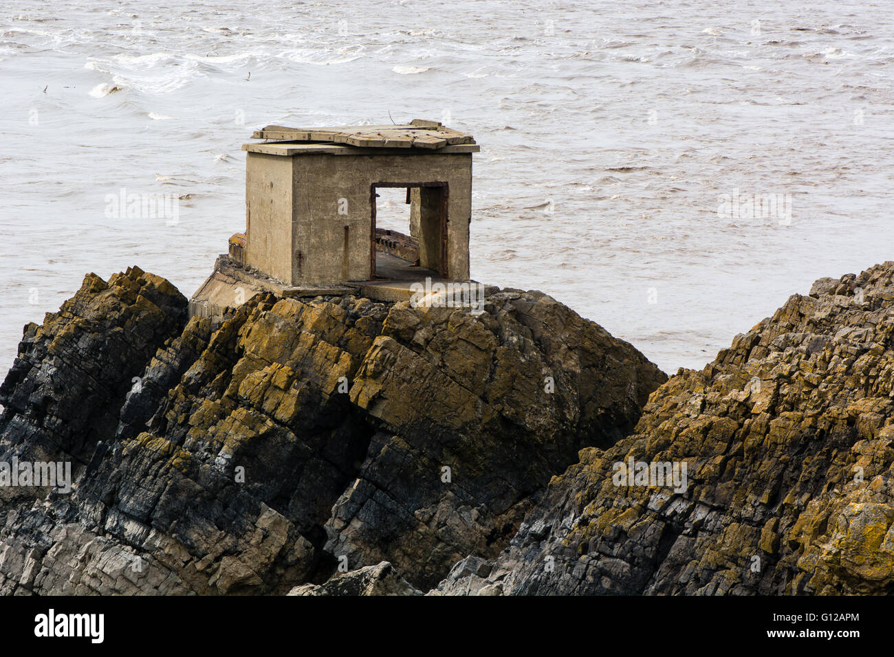Abbandonata la difesa post sulla costa britannica. Una pistola di calcestruzzo stazione sorge su rocce sulla riva del Canale di Bristol, nel Somerset Foto Stock