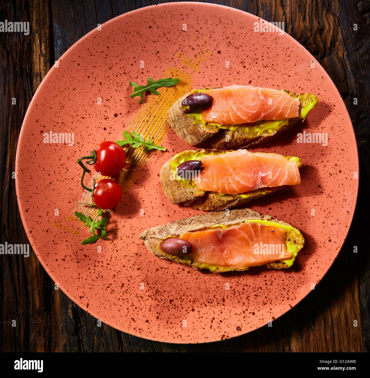 Deliziosa casa salmone affumicato senza glutine crostino guarnito con pomodorini e olive Foto Stock