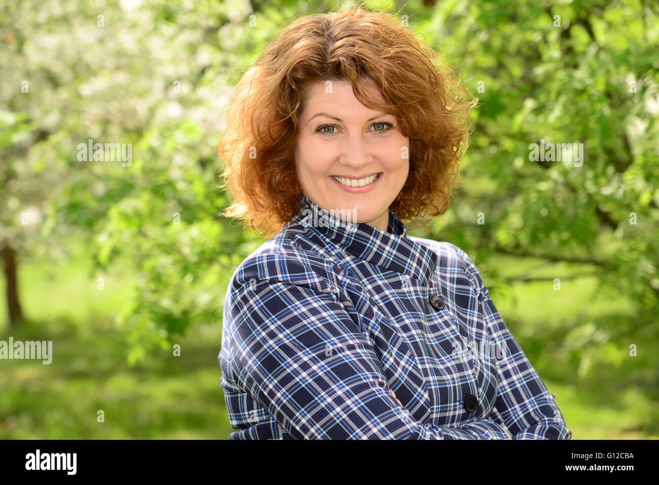 Curly sorridente donna di mezza età al di fuori Foto Stock