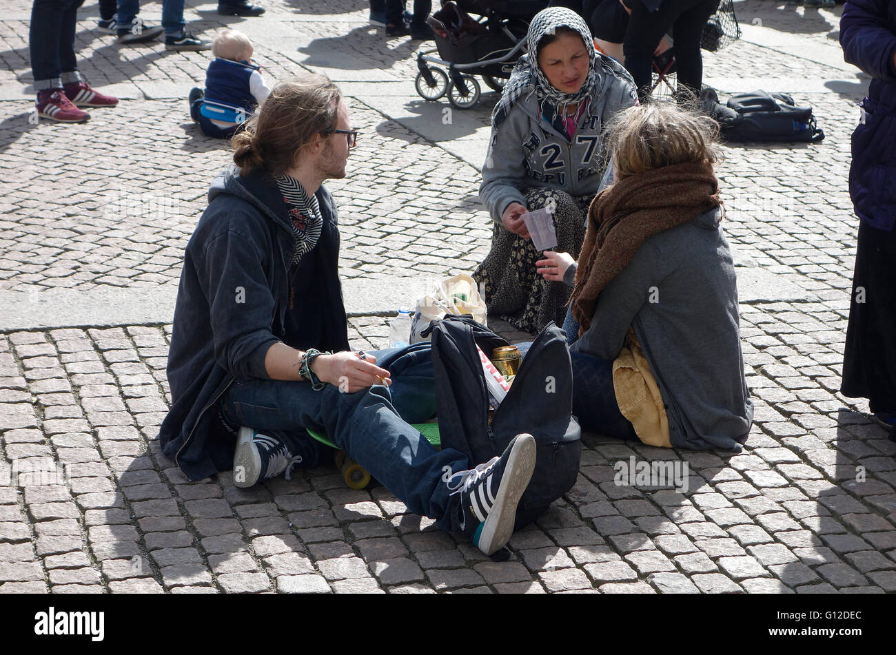 Una giovane donna coinvolta in panhandling aggressivo si avvicina ad una coppia giovane e implora per le donazioni. Gothenburg, Svezia. 2016.04.2 Foto Stock