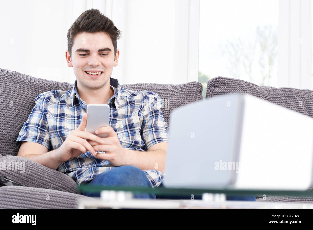 L'uomo streaming di musica dal telefono cellulare per altoparlante senza fili Foto Stock