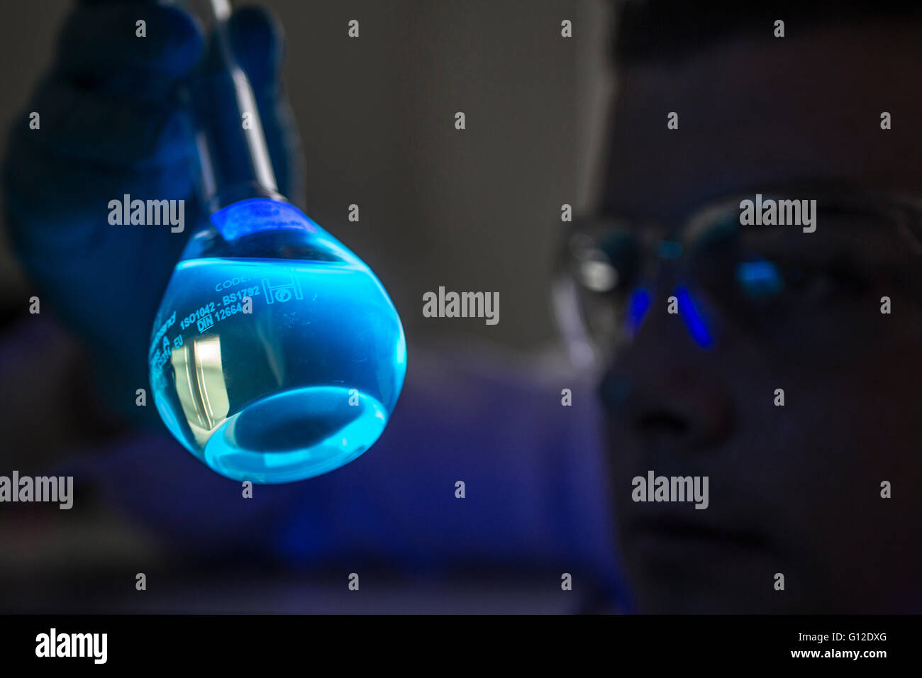 Lo scienziato forense studiare la luminescenza nel campione Foto Stock