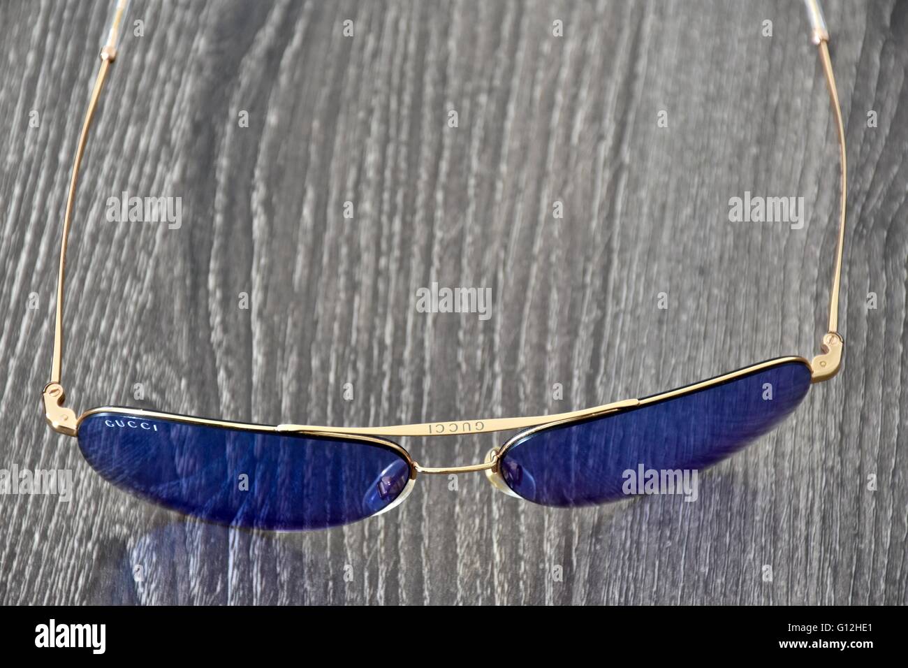 Una coppia di Gucci occhiali da sole su di una superficie di legno Foto Stock