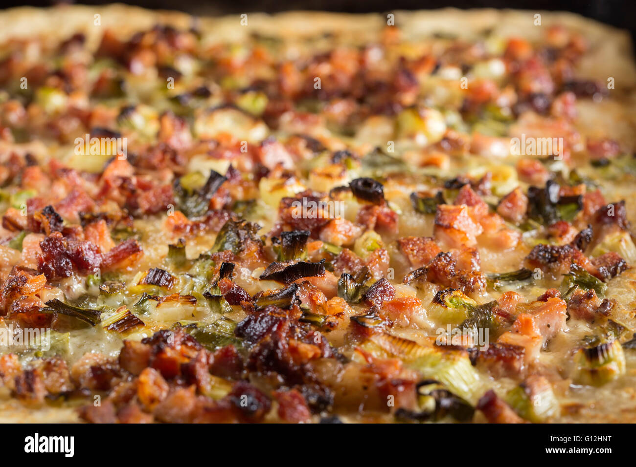 La pizza fatta in casa con la pancetta, cipolla verde e panna acida nel vassoio Foto Stock