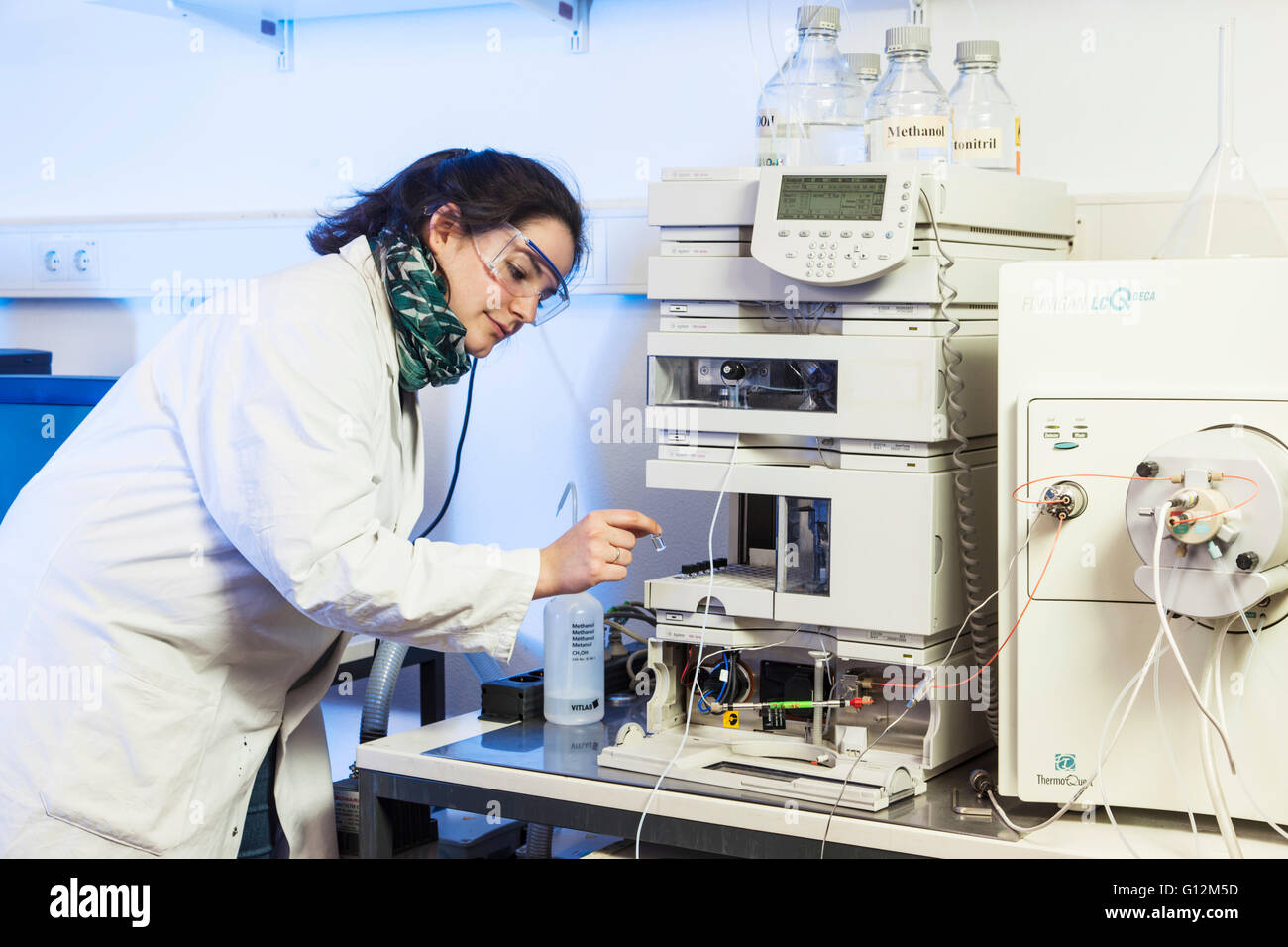 Assistente di laboratorio durante il suo lavoro presso la macchina di analisi dell'istituto. Foto Stock