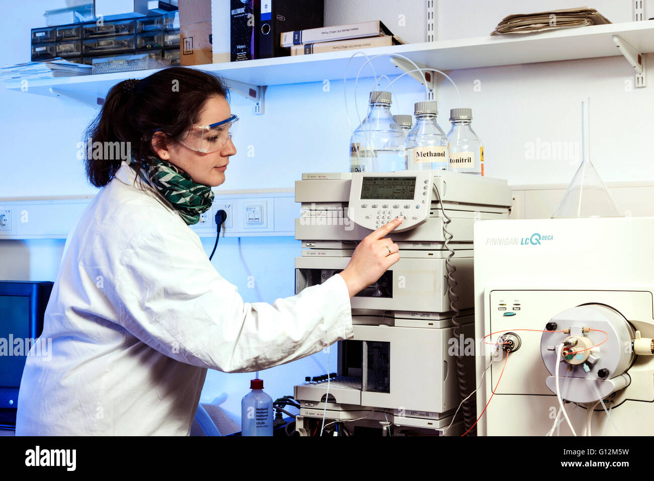 Assistente di laboratorio durante il suo lavoro presso la macchina di analisi dell'istituto. Foto Stock