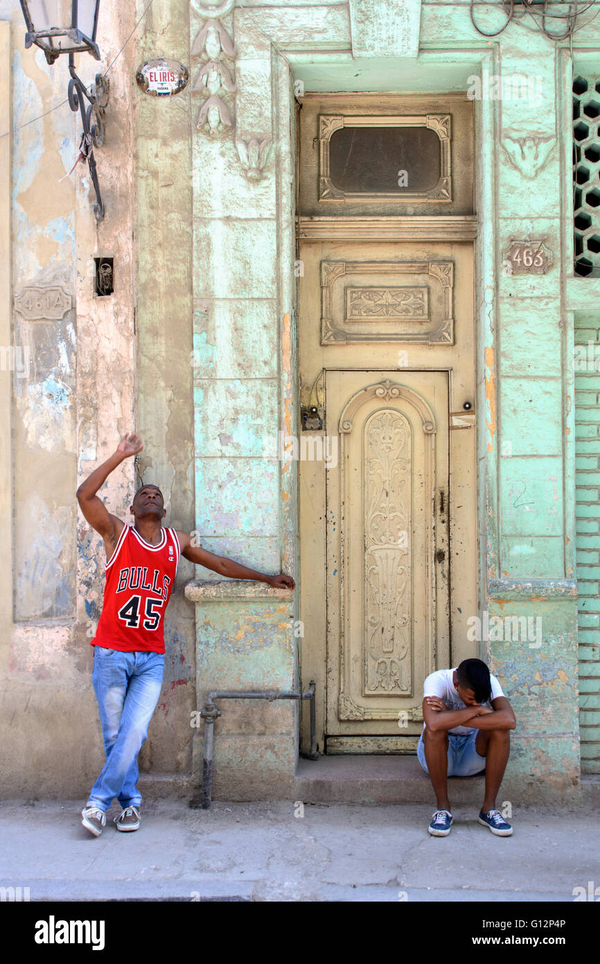 Due giovani uomini al di fuori di un alto porta a l'Avana Vecchia, Havana, Cuba Foto Stock