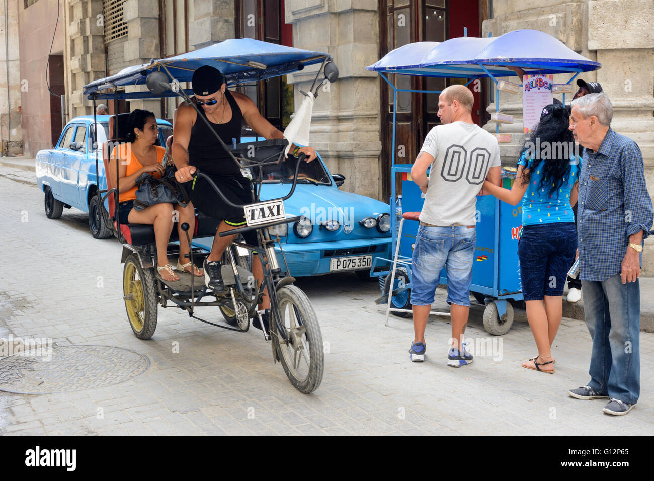 Un risciò bicicletta velocità clienti passati a un gelato stallo nella Avana Vecchia, Havana, Cuba Foto Stock
