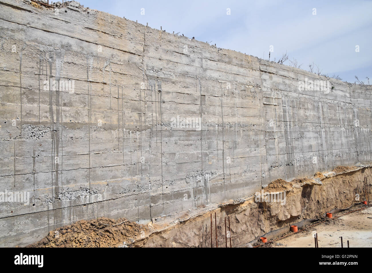 Parete in cemento texture con pattern di legno impressionare dalla forma di legno scheda e armatura con cali di cemento ad un sito in costruzione Foto Stock