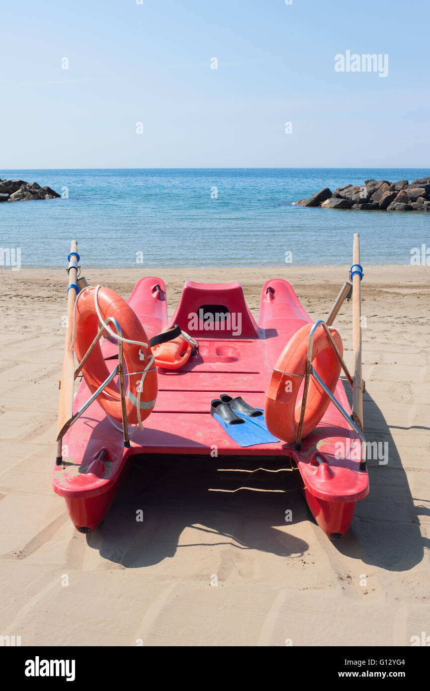Scialuppa di salvataggio sulla spiaggia vuota con il blu del mare e del cielo nella soleggiata giornata estiva Foto Stock