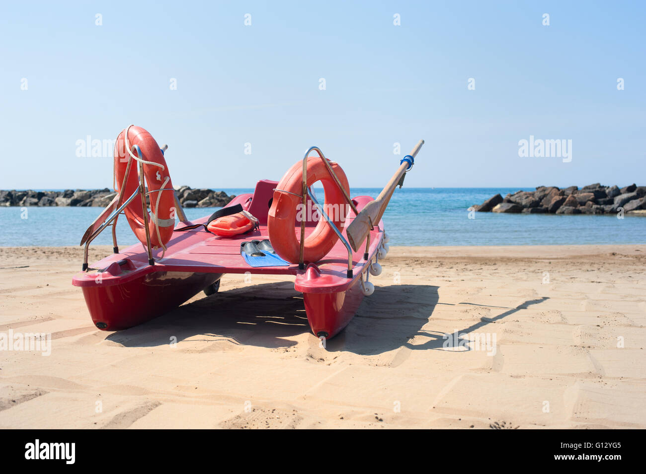 Scialuppa di salvataggio sulla spiaggia vuota con il blu del mare e del cielo nella soleggiata giornata estiva Foto Stock
