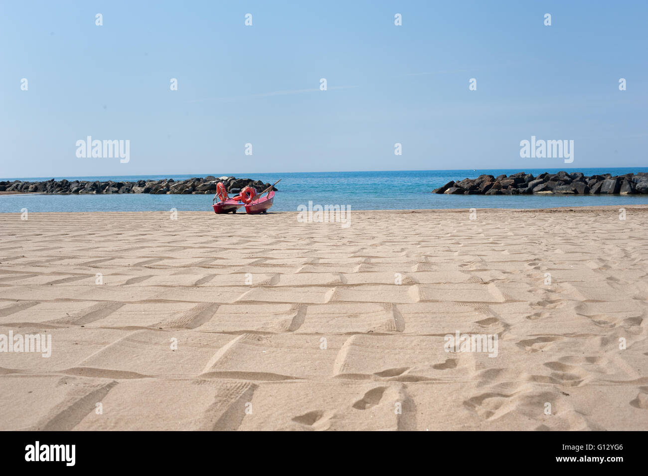 Scialuppa di salvataggio sulla spiaggia vuota con il blu del mare e del cielo nella soleggiata giornata estiva Foto Stock