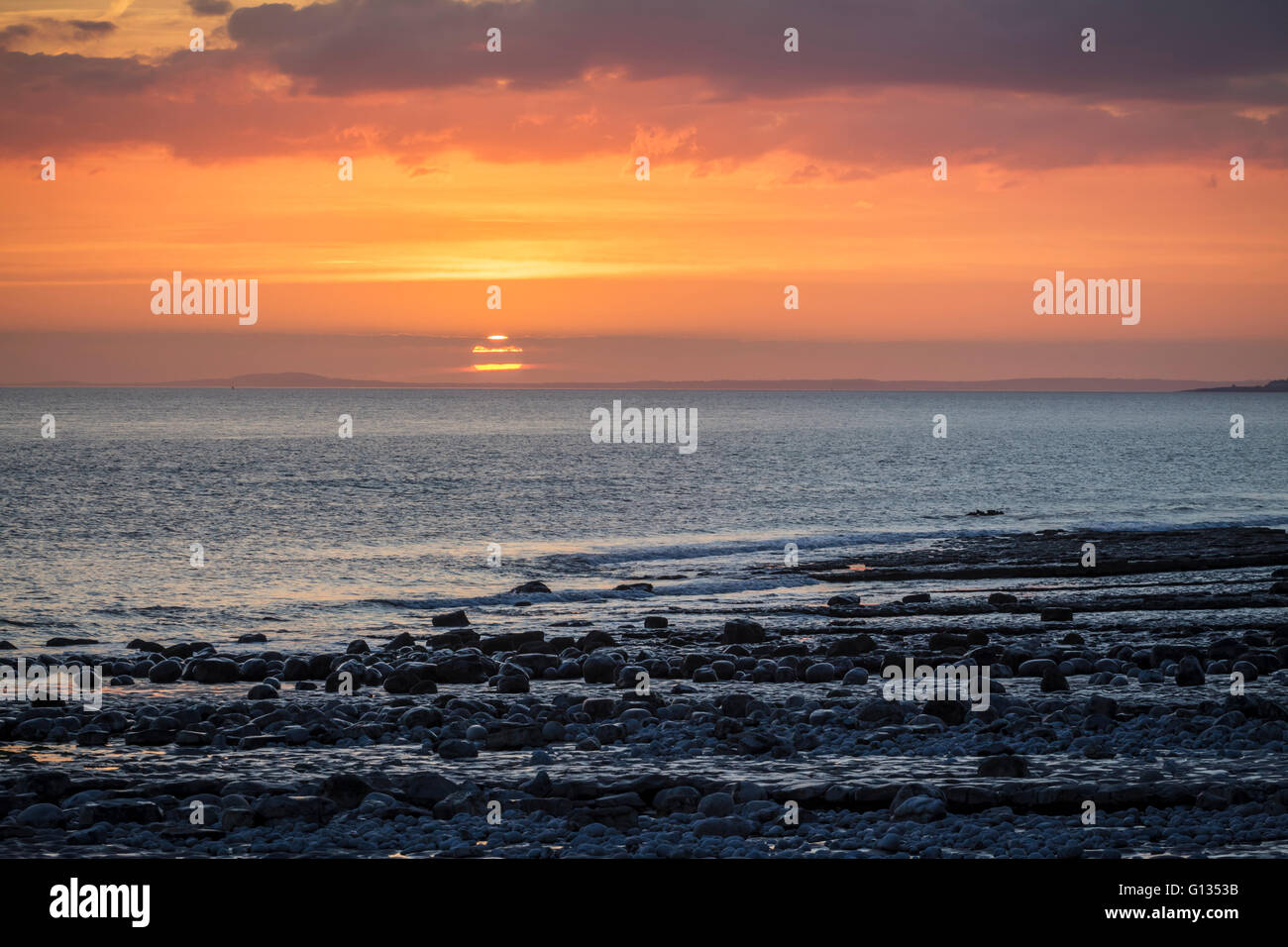 Regolazione del sole sopra il canale di Bristol dall'Glamorgan Heritage costa a Cwm Nash Beach, Galles del Sud Foto Stock