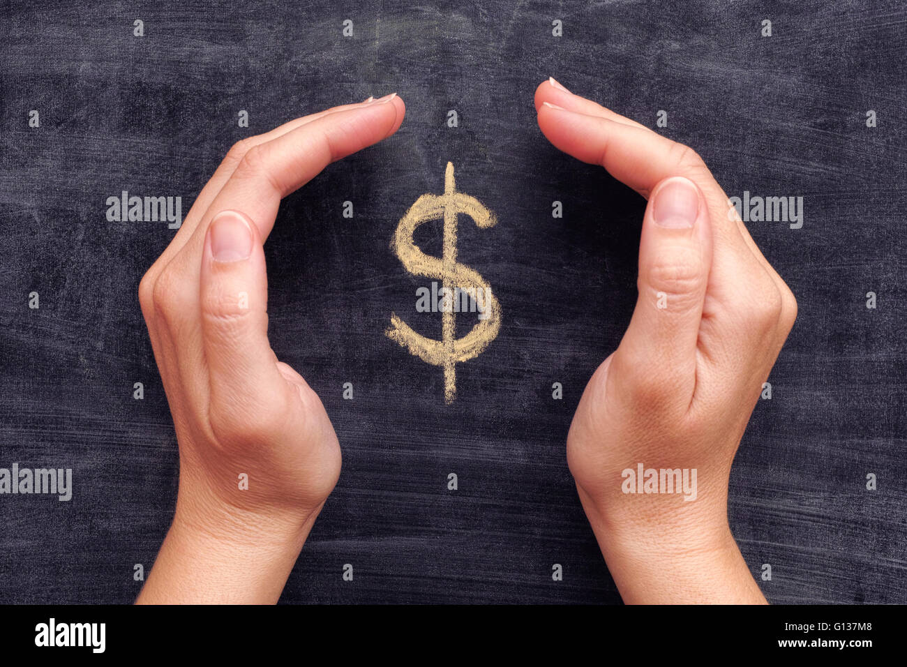 Proteggere le mani disegnate il simbolo del dollaro sulla lavagna nera dello sfondo. Close up. Foto Stock
