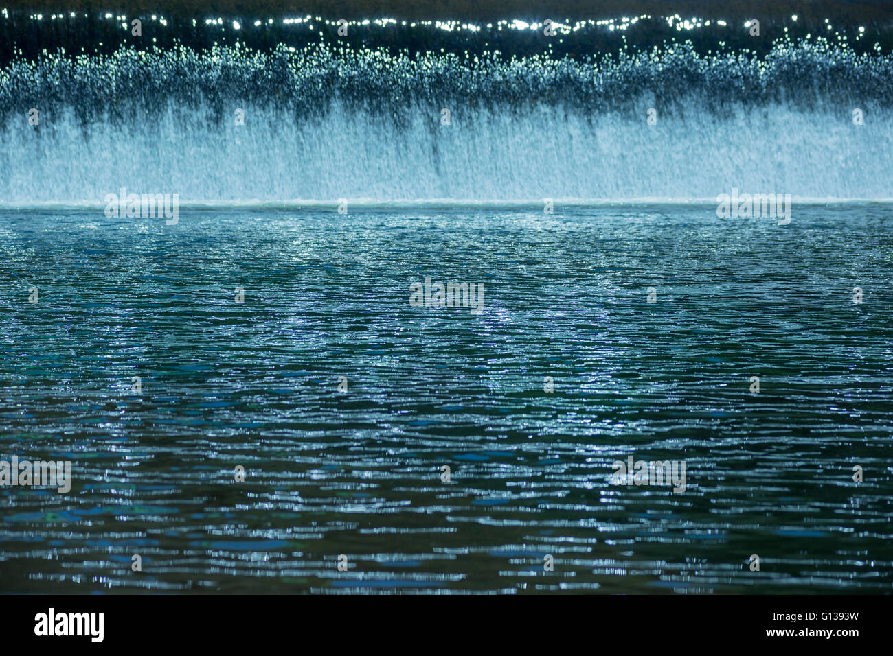 Cortina di acqua fresca CASCADES OVER stramazzo in piscina calma sul piccolo fiume Foto Stock