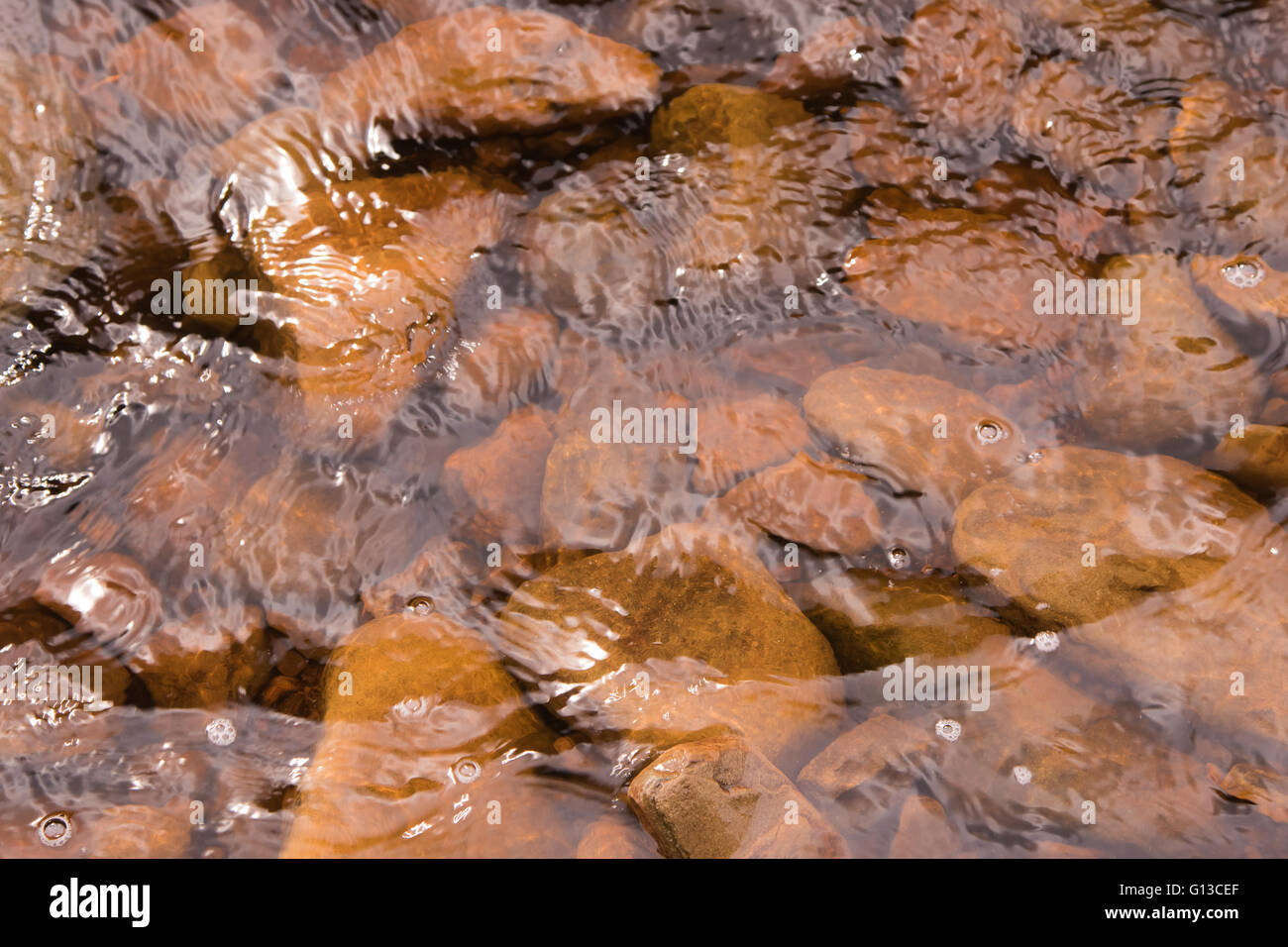 Acqua salmastra su pietre di fiume. Il Peak District. Fiume Alport Foto Stock