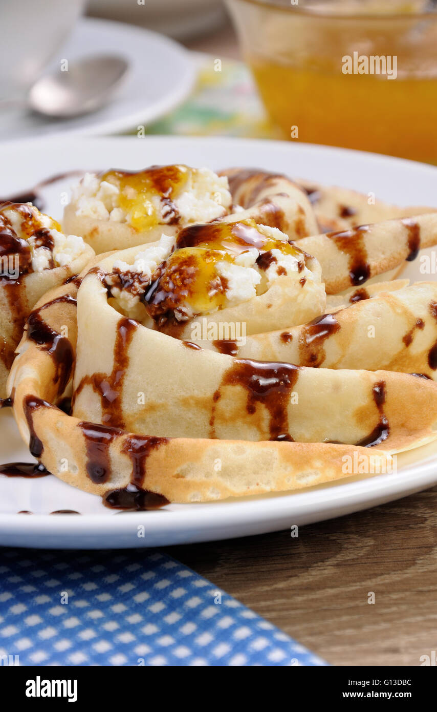 Pancake piegato nella forma di una lumaca per la ricotta con il cioccolato Foto Stock