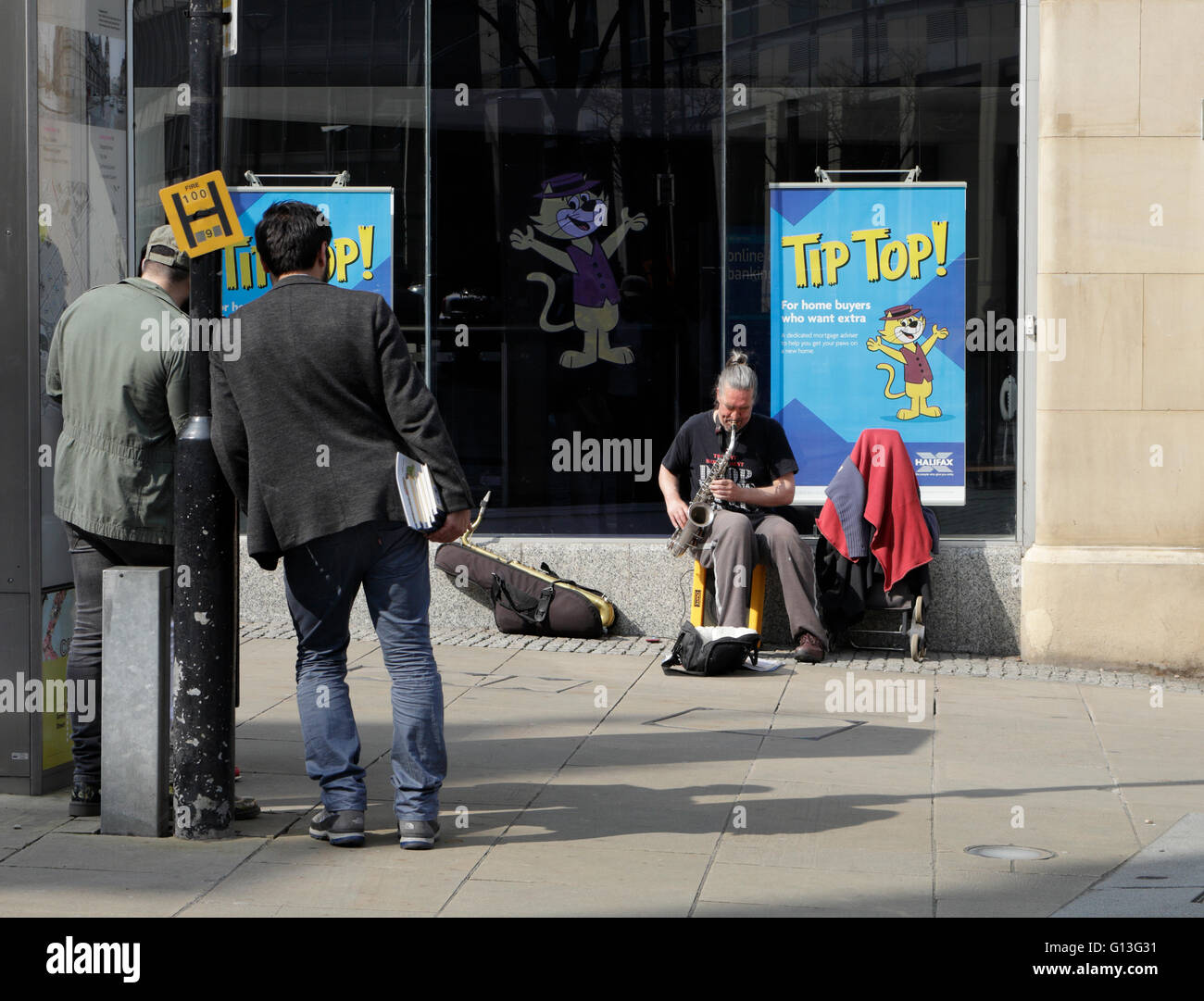 La gente guarda gli autobus di strada che giocano un sassofono, il centro di Sheffield Inghilterra, scena di strada Foto Stock