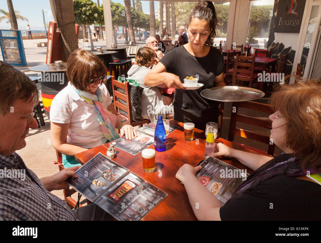 La cameriera che serve bevande ai clienti in un bar Spagnolo a Marbella, Andalusia, Spagna Europa Foto Stock