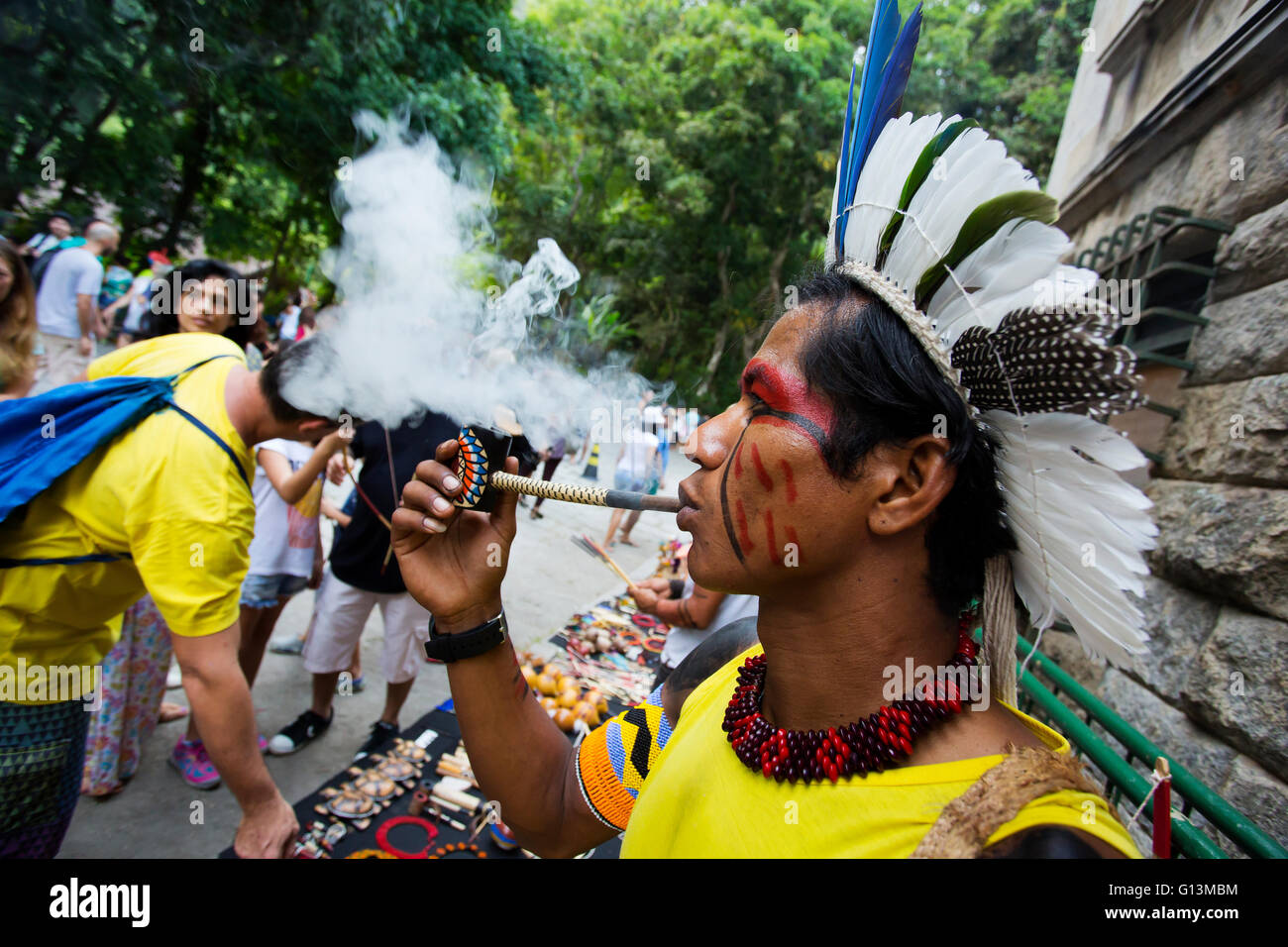 Brasiliano tradizionale indiano con faccia dipinta fumare la pipa al Parque Laje nel comemoration dell'indiano del giorno, Rio de Janeiro, Brasile Foto Stock