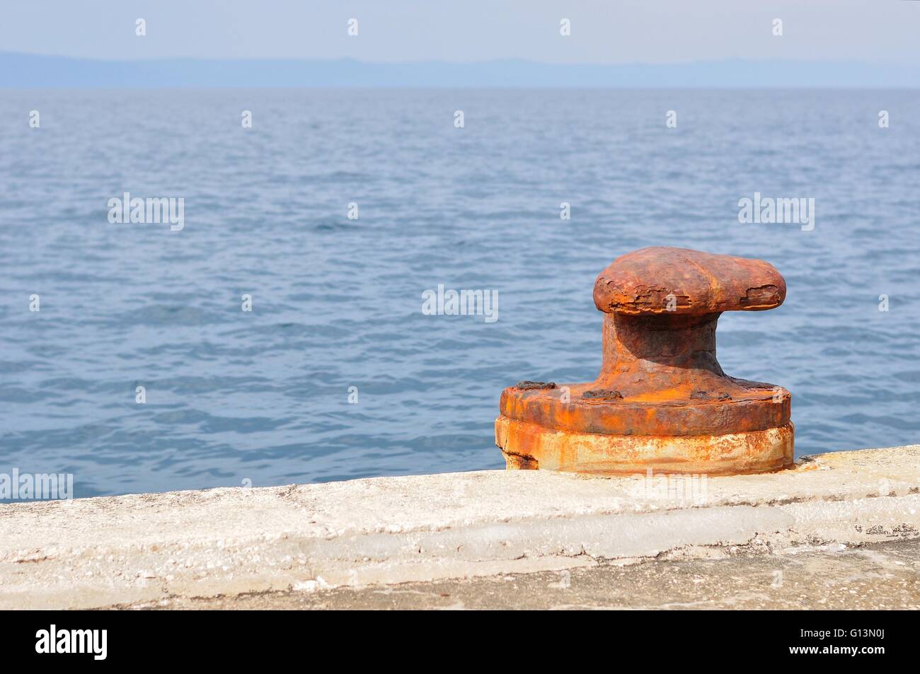 Vecchie e arrugginite bollard ormeggio sul porto di Podgora, Croazia. Spazio sul lato sinistro. Foto Stock