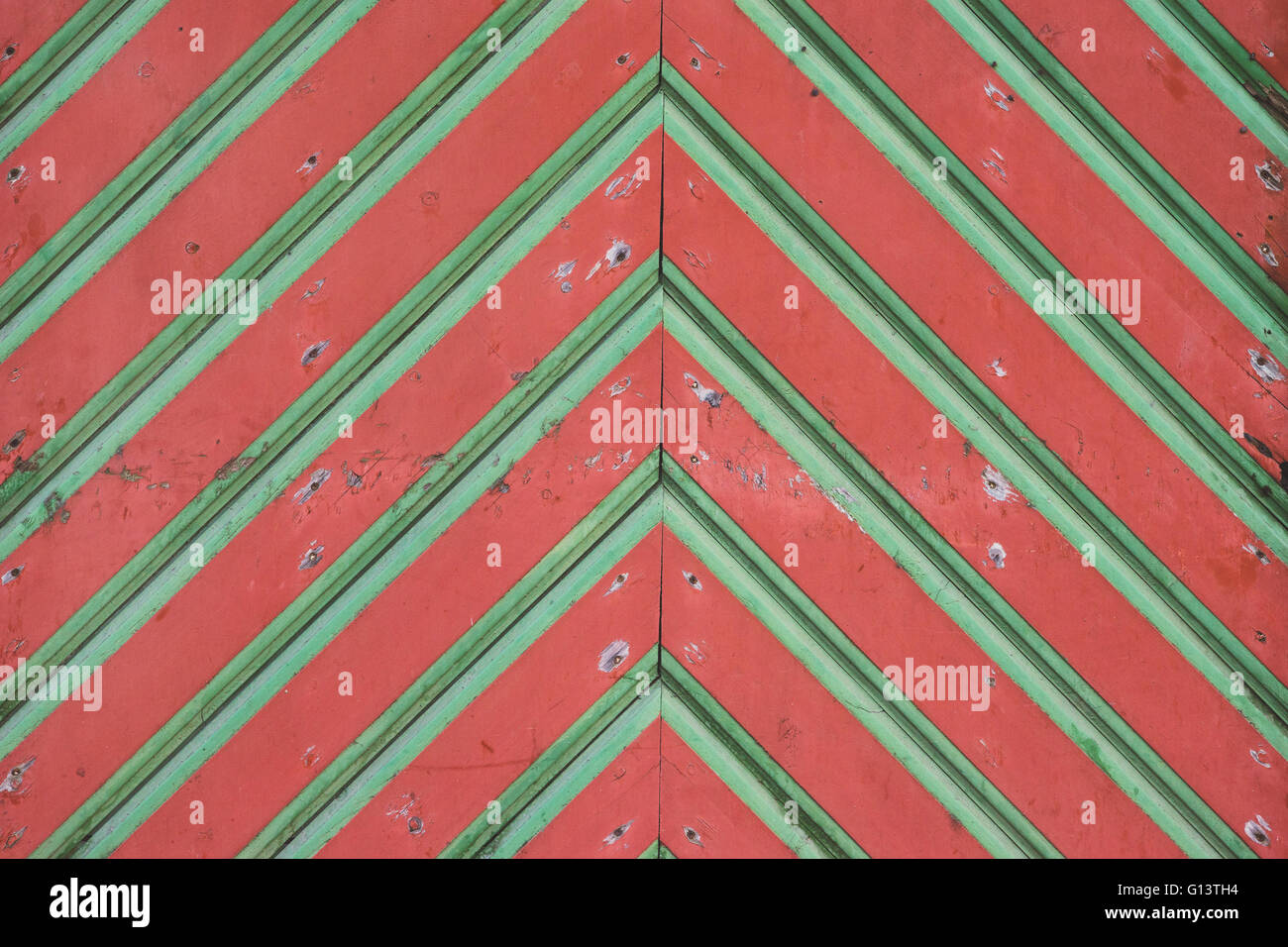 Primo piano sul vecchio rosso-verde cancelli in legno in cattivo stato, stile medievale e architettura Foto Stock