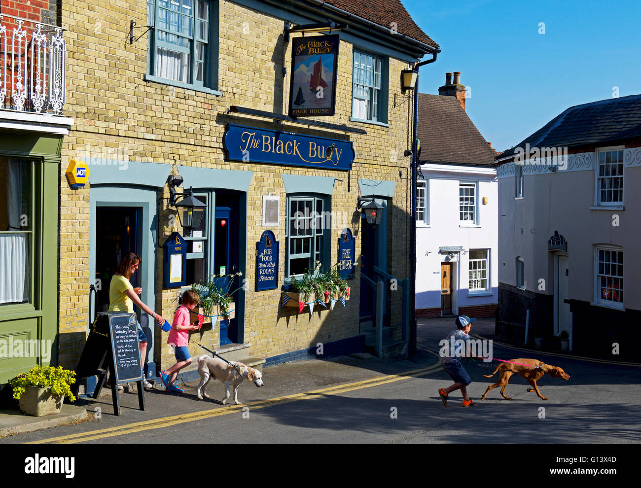La famiglia lasciando la boa nero pub in Wivenhoe, Essex, Inghilterra, Regno Unito Foto Stock