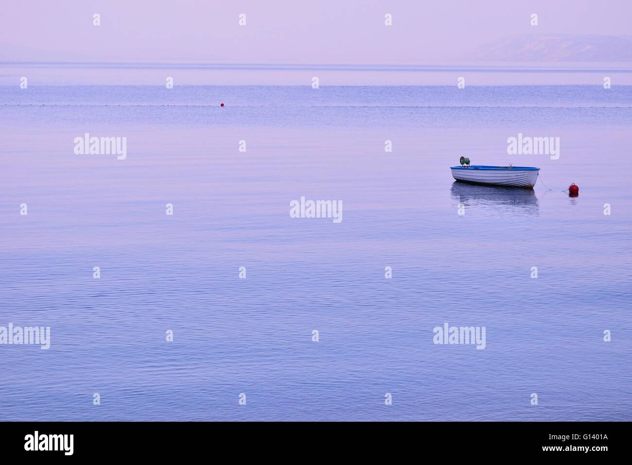Piccolo lonely barca da pesca galleggianti sulla superficie piatta del mare adriatico sulla calma mattina Foto Stock