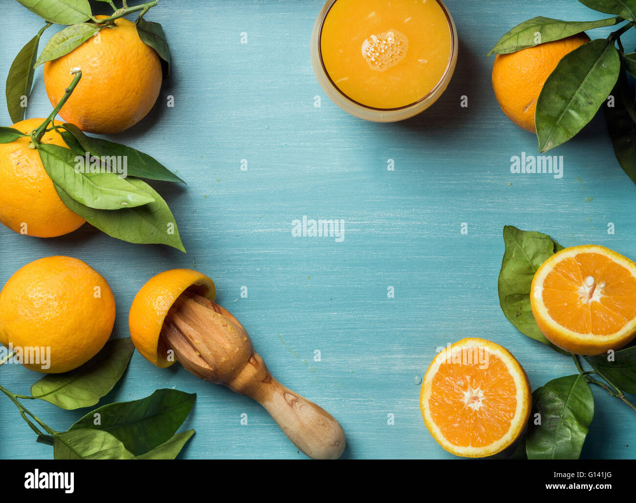 Il succo d'arancia fresco in vetro e le arance con foglie sul turchese in  legno dipinto di blu dello sfondo. Vista superiore, spazio di copia Foto  stock - Alamy