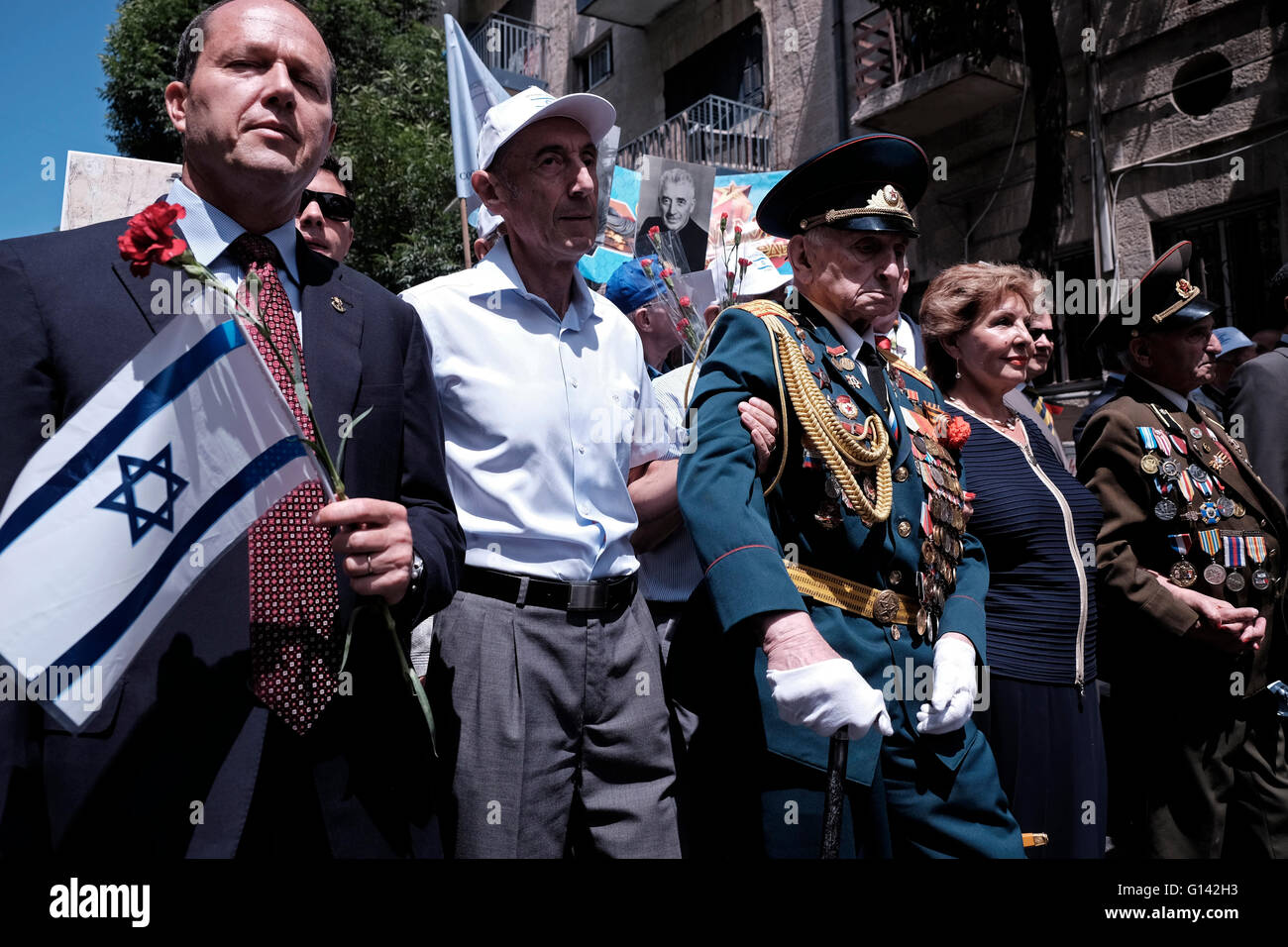 Gerusalemme, Israele. 8 maggio 2016. Il sindaco di Gerusalemme NIR Barkat detiene la bandiera israeliana mentre cammina con i veterani della seconda guerra mondiale sovietica ebraica con medaglie incagliate nelle loro vecchie uniformi durante una parata in onore di 71 anni dalla vittoria degli alleati sulla Germania nazista nella seconda guerra mondiale, nel centro di Gerusalemme credito: Eddie Gerald/Alamy Live News Foto Stock