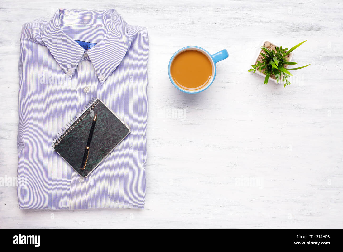 Maglietta uomo d'affari, una tazza di caffè e blocco note su bianco sullo sfondo di legno. Business e concetto di ufficio. Stile di vita. Foto Stock Maglietta uomo d'affari, una tazza di caffè e blocco note su bianco sullo sfondo di legno. Business e concetto di ufficio. Stile di vita. Foto Stock