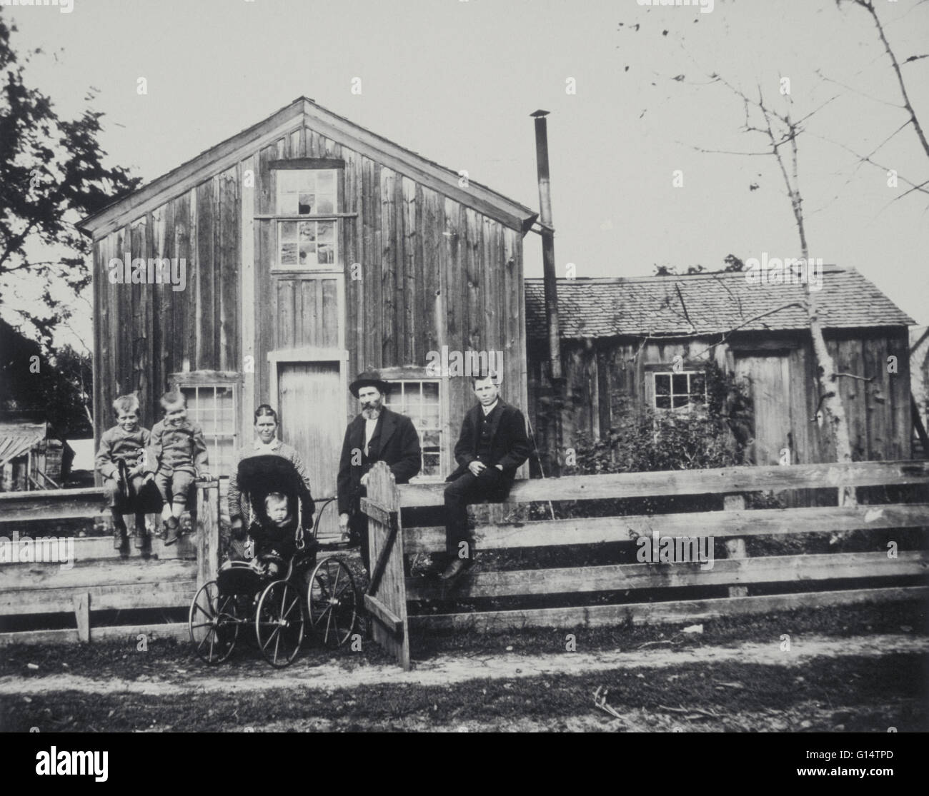 Foto in bianco e nero di una famiglia. Famiglia sta al di fuori della loro casa, probabilmente vicino al Black River Falls, Wisconsin. Foto Stock