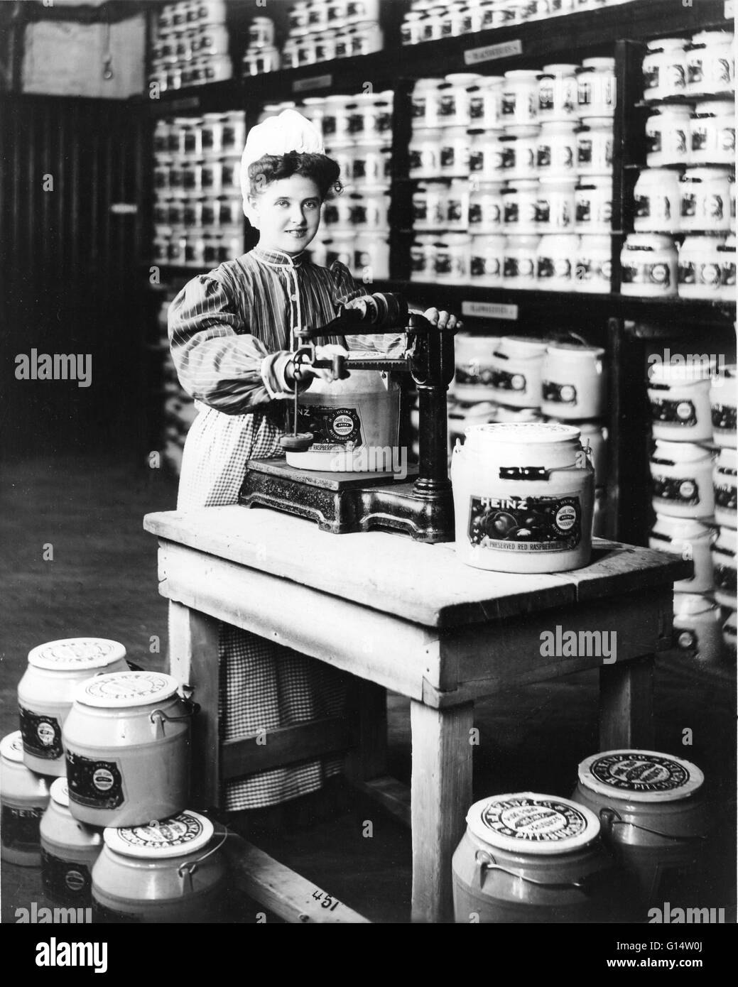 Una ragazza del peso di conserve di lamponi rosso presso la società Heinz. Foto Stock