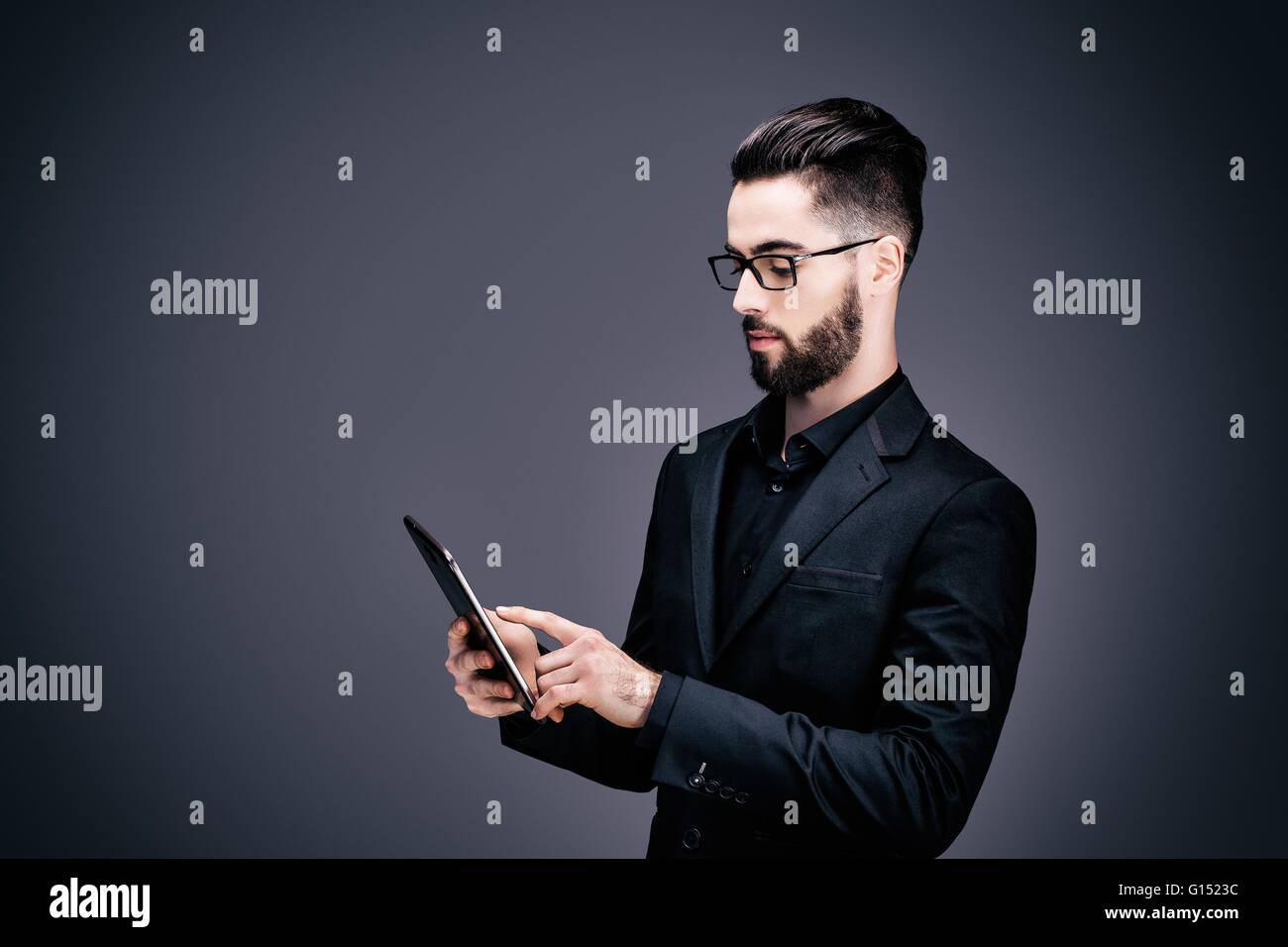 Ritratto di un giovane imprenditore tenendo un touch pad nelle sue mani Foto Stock