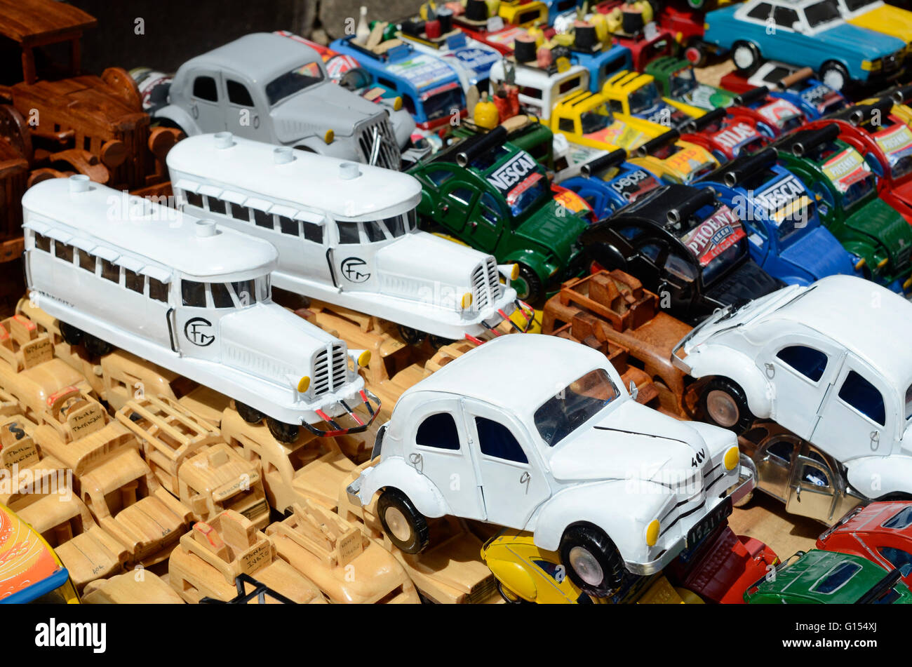 MADAGASCAR, città Antananarivo, venditore ambulante vende piccoli toy cars Citroën 2CV e miniatura del treno francese Micheline riciclaggio di lattine per bevande Foto Stock
